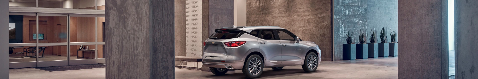 近代的な建物の外に駐車されたシルバーSUV